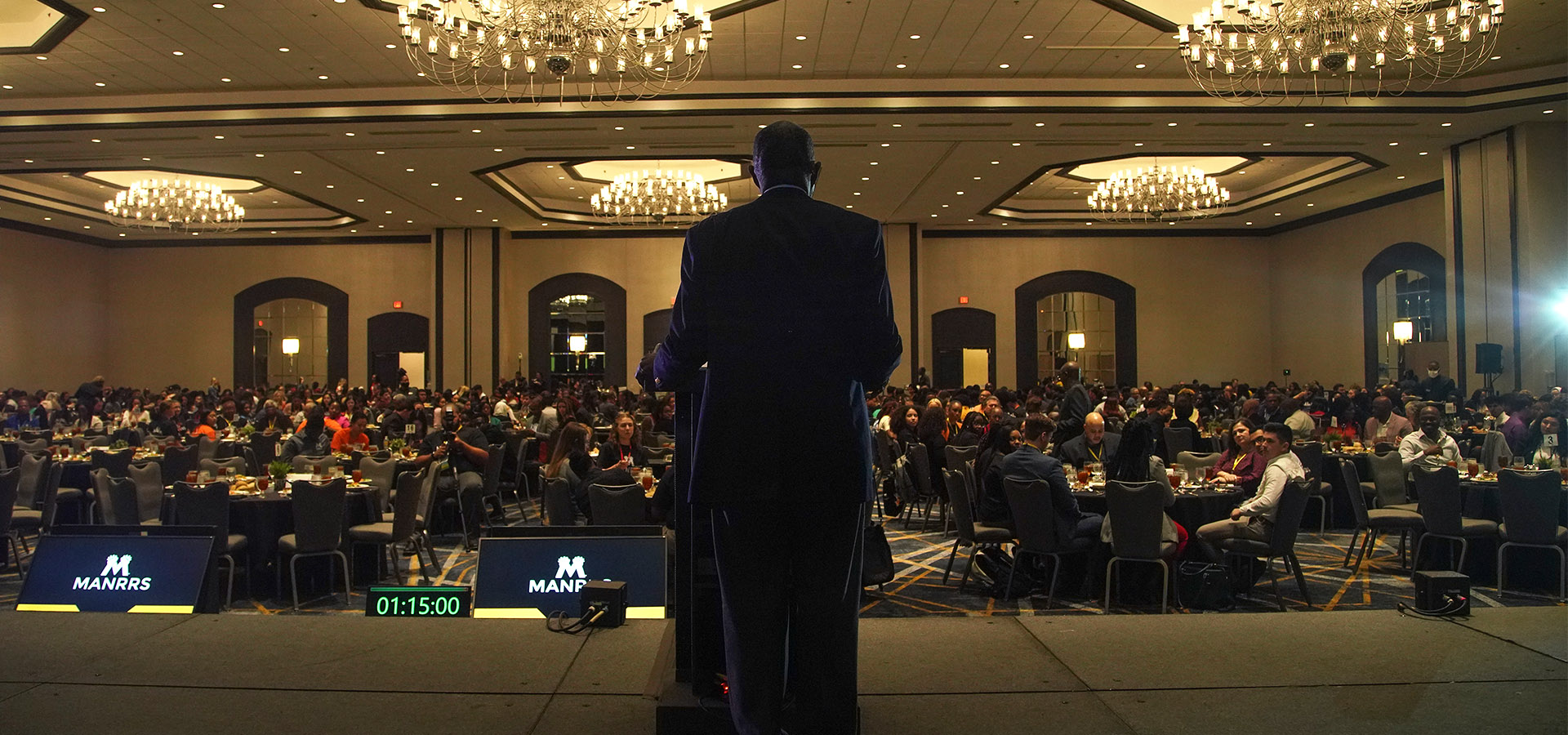 Backview of Conference Speaker on Stage